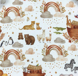 Patterned fabric with animals, rainbows, and clouds on a white background