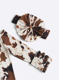 Cow print headband and leg warmers on a white background