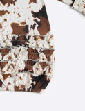 Close-up of a brown and white patterned fabric with ruffled layers on a white background
