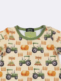 Children's shirt with farm-themed design featuring tractors and barrels on a beige background.
