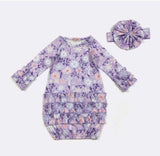 Purple floral baby dress with matching headband on a white background