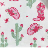 Pattern of pink cowboy boots, hats, and cacti on a white background