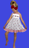 Young girl wearing a dress with American flag pattern against a blue background