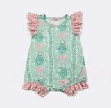 Green baby romper with turtle and bow pattern on a white background