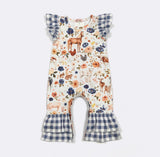 A baby girl's one-piece jumpsuit featuring a woodland print with deer, birds, and flowers on an off-white background, with blue and white gingham ruffle details on the shoulders and leg cuffs.