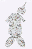 A baby footed sleeper and matching hat set with an all-over duck and reeds print on a white background, displayed flat against a light gray backdrop.