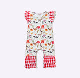 A baby romper with a white background covered in a colorful farm animal and floral print, featuring red and white gingham ruffle trim on the sleeves and legs.