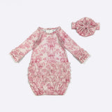 Pink floral baby romper with matching headband on a white background