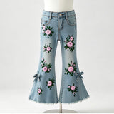 Light blue denim flare jeans with pink floral embroidery and green leaves, displayed on a white mannequin against a light gray background.