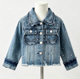 A light blue denim jacket with scalloped ruffle trim and white pearl embellishments, displayed on a white mannequin torso against a plain white background.