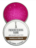 A small, round tin Fredericksburg Farms air freshener with a pink solid color interior, labeled 'Vanilla Birch'.