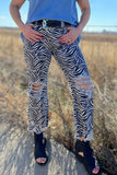 Person wearing zebra print pants with a blue top in an outdoor setting