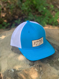 Blue trucker hat with a leather patch on the crown with 1776 on it Close up