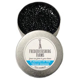 A small, round tin Fredericksburg Farms air freshener with a blue solid color interior, labeled 'Flapping in the Texas Breeze.