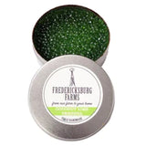 A small, round tin Fredericksburg Farms air freshener with a green solid color interior, labeled 'Coconut Lime Verbena'.