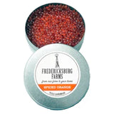 A small, round tin Fredericksburg Farms air freshener with a orange solid color interior, labeled 'Spiced Orange'.
