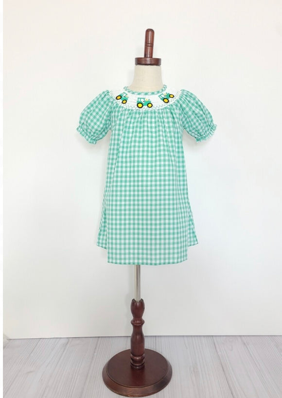 Green smocked short sleeved dress with tractors around the collar - on mannequinn
