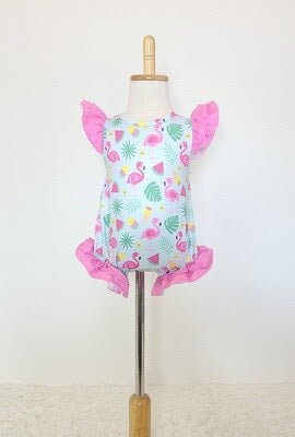 Baby romper by Clover Cottage with pink ruffle sleeves and leg openings